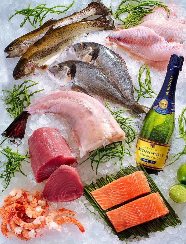 Selection of various raw fish and ctabbas, champagne bottle, on ice, studio recording