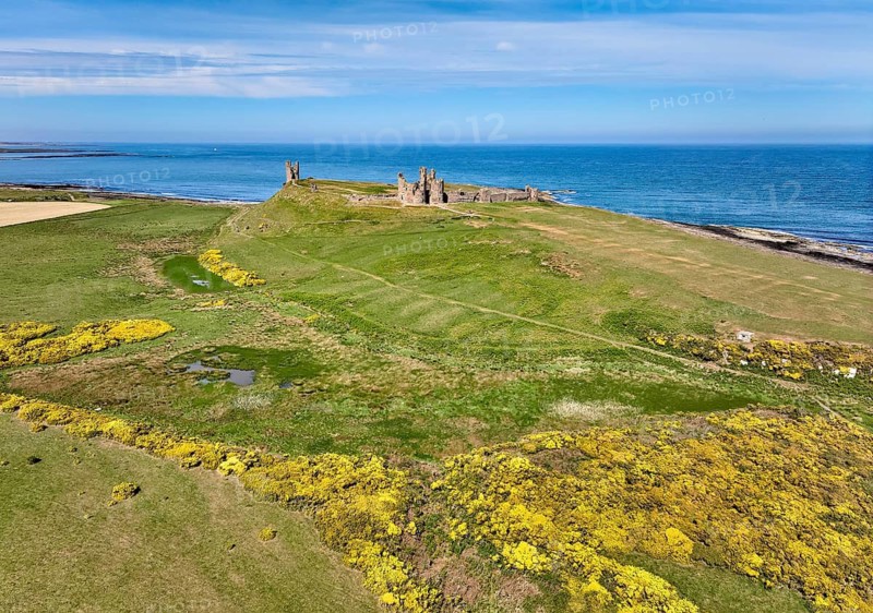 Aerial photo of Dunstanburgh Castle at the north sea coast in Northumberland, England, UK