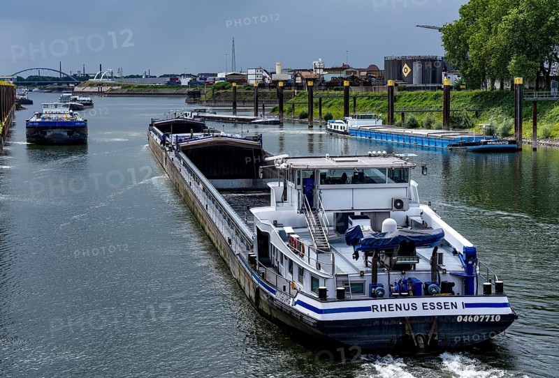 Freight ships in the port canal in the port of Duisburg-Ruhrort are waiting in front of the Duisburg-Meidrich canal lock to continue their journey east on the Rhine-Herne Canal, a freighter has just left the lock heading westwards towards the Rhine, North Rhine-Westphalia, Germany