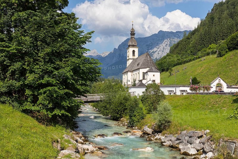 Famous view of the parish church of St. Sebastian with bridge over the Ramsauer Ache in the Ramsauer Malerwinkel with horse-rider Alm and Wagendrischelhorn, Ramsau near Berchtesgaden, Berchtesgadener Land, Bavaria, Germany