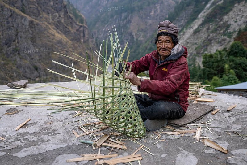 Nepalese, local of the Tsumba Tibetan ethnic group weaving a basket, traditional crafts, Tsum Valley, Himalayas, Nepal