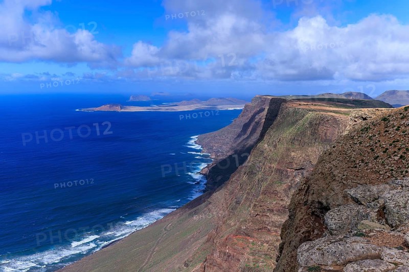 Lanzarote, Canary Islands, Spain, Europe, Mirador de El Risco de Famara, Parque El Bosquecillo, view from high cliffs of the deep blue sea and distant islands under a clear sky