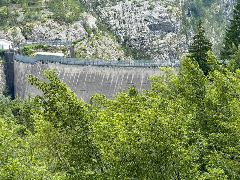 Crown of Vajont dam in front of forest trees grow on site of landslide from Monte Toc disaster disaster in Longarone, Veneto, Italy