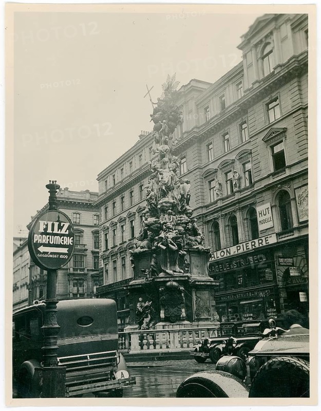 Vienna, Am Graben, Plague Column, Taxi, Salon Pierre, Rain A lively town square with a large monument and old buildings in the background, around 1920