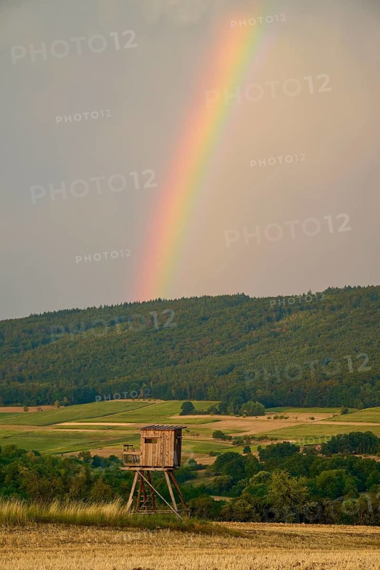 High seat in front of a rainbow over wooded hills and fields, summer, Großheubach, Miltenberg, Spessart, Bavaria, Germany