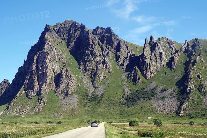 Impressive mountain landscape with steep rock formation next to a country road, Bleik, Andøya, Nordland, Norway