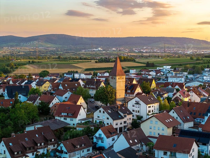 Village in soft evening light with distinctive church tower and red roofs, nestled in hilly landscape, Korb-Steinreinach, Remstal, Baden-Württemberg, Germany