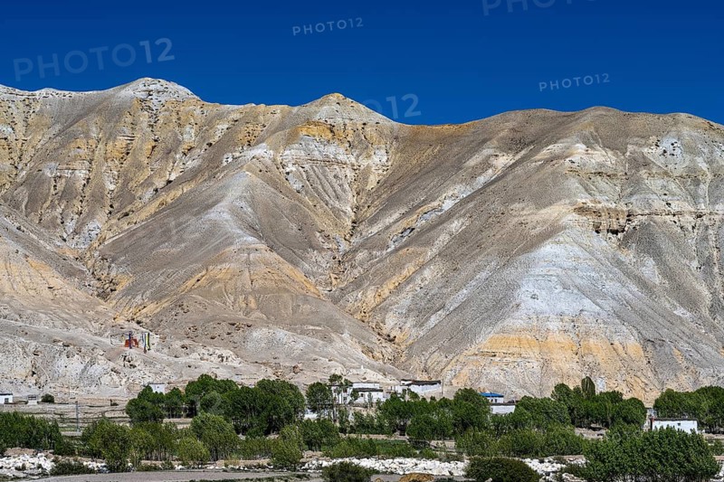Small settlement and cultivated fields in front of mountainous landscape, erosion landscape near Lo Manthang, Mustang, Upper Mustang, former kingdom, Himalayas, Nepal