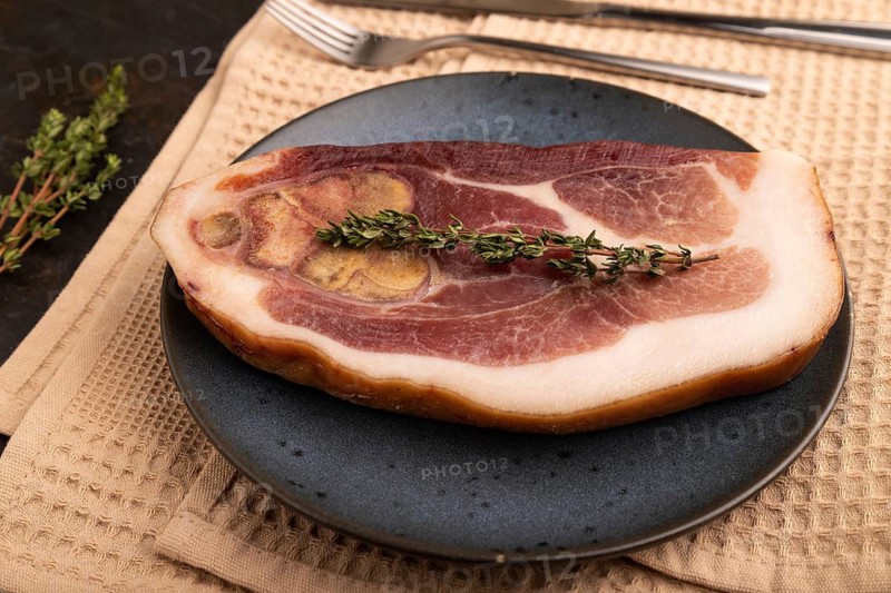 Dry-aged steak, Pork ham with thyme on black concrete background and beige linen textile. side view, close up