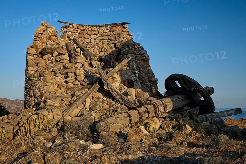 Windmill above Chorio on Mount Xaplovouni, ruin of a building with wooden parts in the foreground, main town on Kimolos, Kimolos, Chorio, Kimolos island, neighboring island of Milos, Cyclades, Greek Islands, Greece