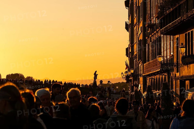 Crowd at sunset on the river Arno, light-filled evening mood, back light, old town, Florence, Tuscany, Italy