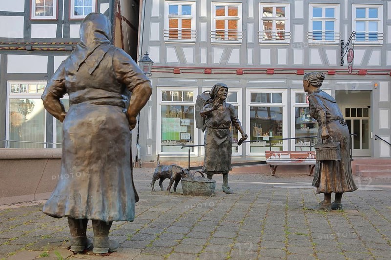 Market Women sculpture by Ewald Rumpf 2009, modern art, bronze sculpture, life-size, three standing woman with index finger, gesture, arm up, gossip, talking, listening, telling, communication, dog figure on shopping basket, market square, Rotenburg an der Fulda, Hesse, Germany