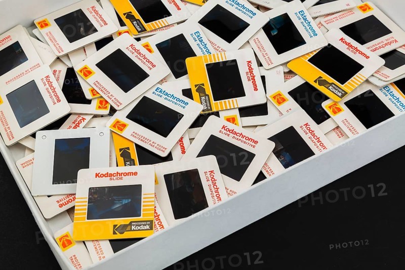 Opened storage box of old loosely arranged 1980s 35mm Kodak Kodachrome and Ektachrome slides mounted in white cardboard frames with bilingual English and French wording for the Canadian market, Studio Composition, Quebec, Canada
