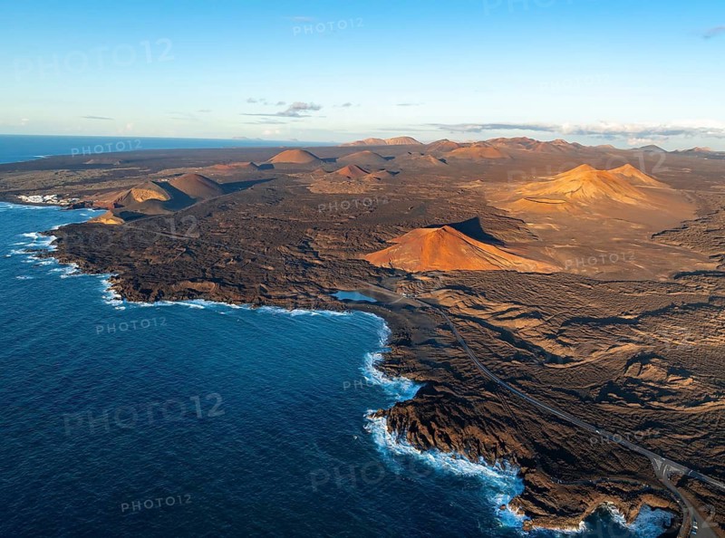 Coast with lava fields, volcanic landscape near Los Hervideros with red volcano Montaña Bermeja, in the evening light, aerial view, Lanzarote, Canary Islands, Spain