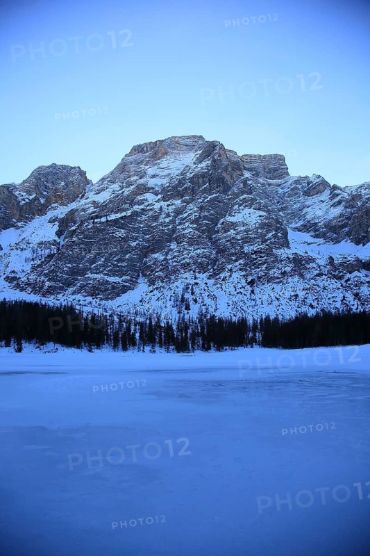Quiet winter landscape with snow-covered mountains and frozen lake in cold light, Pragser Wildsee, Lago di Lake Prags, frozen mountain lake in winter, Prags, Lake Prags, South Tyrol, Italy