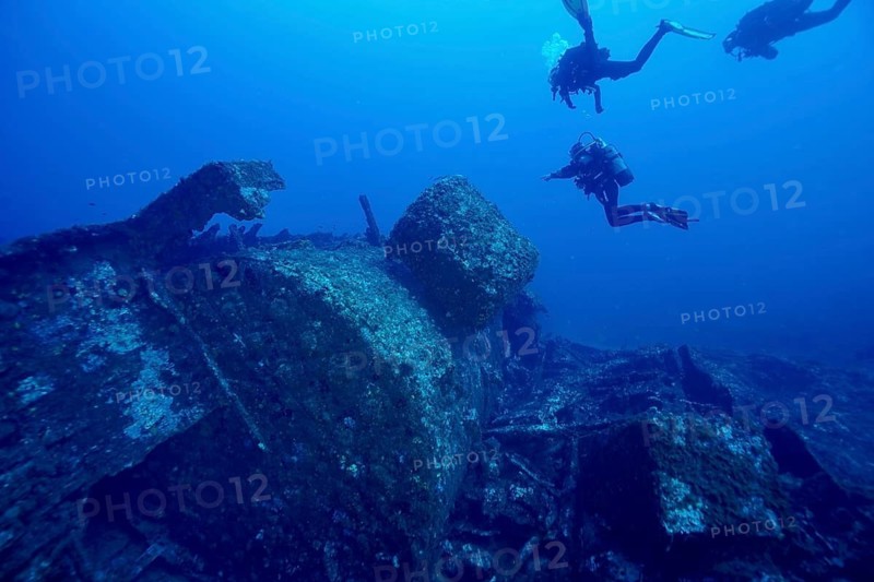 Divers explore a large shipwreck underwater in the deep sea, dive site Wreck Michel C, Hyères, Giens Peninsula, Mediterranean, Provence Alpes Côte d'Azur, France
