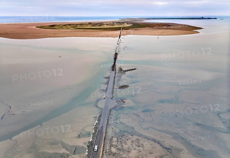 Aerial drone photograph of the causeway with floated road leading to Holy Island and Lindisfarne, Northumberland, England, at low tide