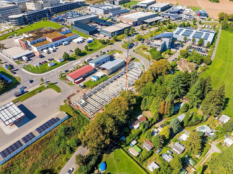 Aerial view of a large construction site with crane and industrial park in the background, Parkhaus Bau, Calw, Germany