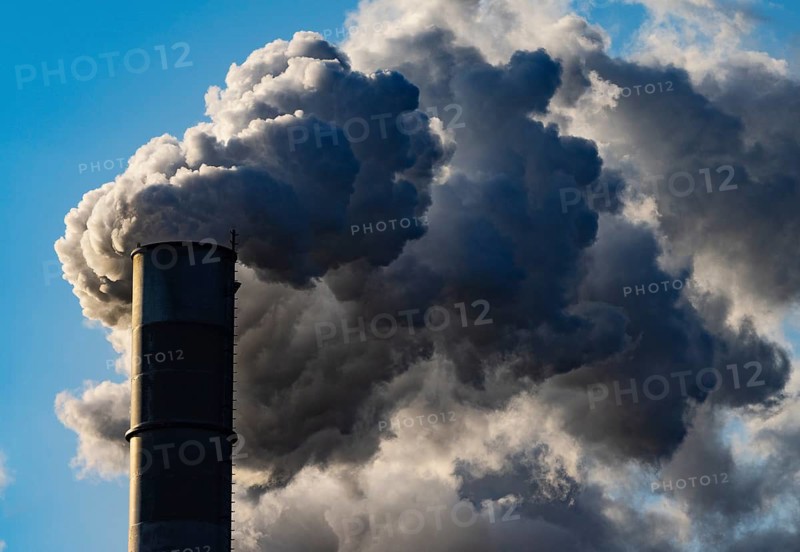 Smoke flows from a factory chimney against a blue sky, air pollution, industry, climate protection, Austria