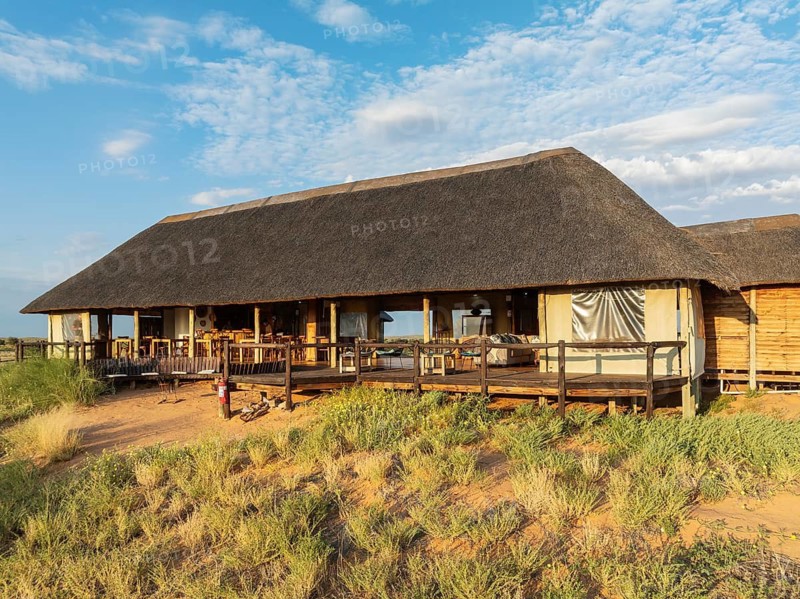 The main building of the Ta Shebube Rooiputs Lodge in the Kalahari Desert during the rainy season with green vegetation. Drone shot. Kgalagadi Transfrontier Park, Botswana