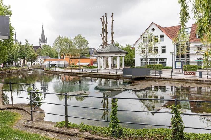 Lippequelle, Armeniusquelle and city view with Kath. St. Martin Parish Church, Bad Lippspringe, North Rhine-Westphalia, Germany