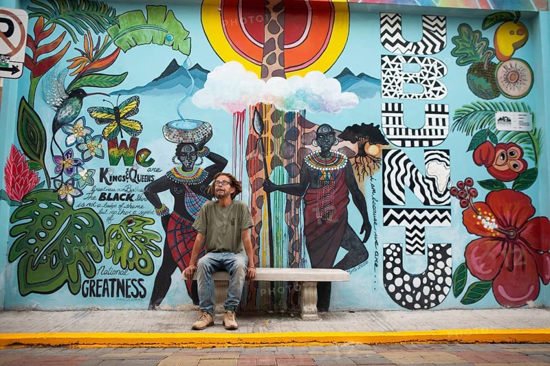German Rastafarian in front of a painted façade in Waterlane in Kingston, Kingston Parish, Jamaica, West Indies, Caribbean, Central America