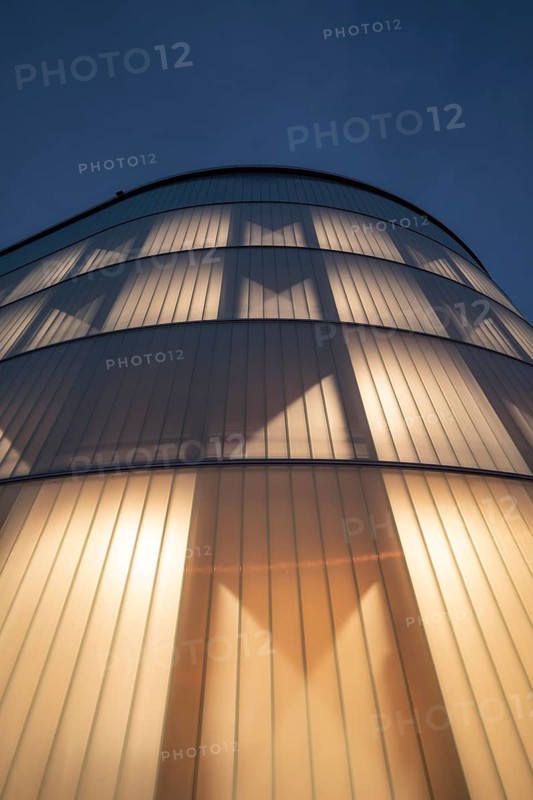 03.05.2026: Illuminated modern timber parking garage (Parkhaus am Bahnhof) with a curved wooden facade at dusk. Wendlingen am Neckar, Baden-Württemberg, Germany