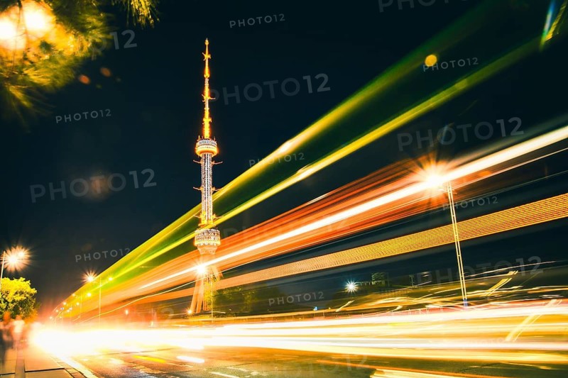 Tashkent soviet architecture TV tower Uzbekistan. Time lapse night city traffic light trails illuminated broadcasting tower urban skyline long exposure motion
