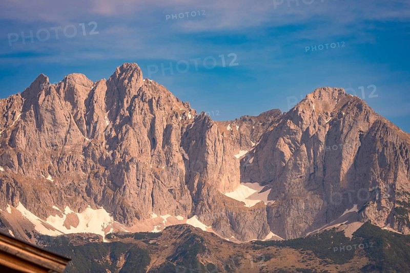 Extensive mountain landscape with rocky peaks and snowfields under blue skies, Hahnenkamm, Kitzbühel, Austria