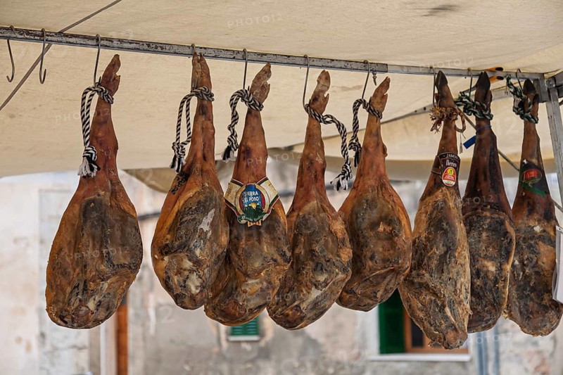 Sales stand with whole pork ham, farmers market, weekly market market, Sineu, Majorca, Spain