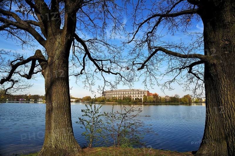 A general view of the former, unfinished NSDAP Congress Hall, 1933–1945, with the Dutzenteich and lime trees (Tilia platyphyllos) in the foreground, Documentation Centre, Reich Party Rally Grounds, Bayernstraße 110, Nuremberg, Middle Franconia, Bavaria, Germany