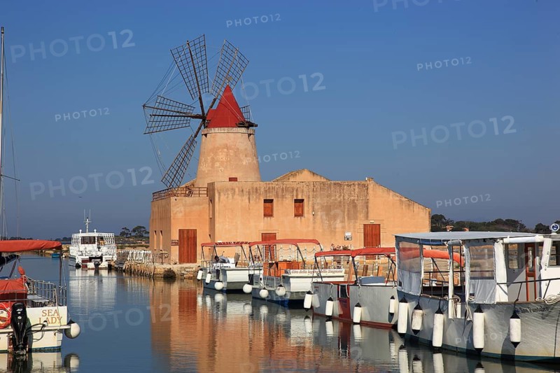 Sicily, windmill and boats at the Mozia saltworks near Marsala, Italy