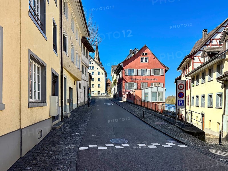 Narrow, steep cobblestone road with colorful, historic buildings and blue sky, Diessenhofen, Canton of Thurgau, Switzerland