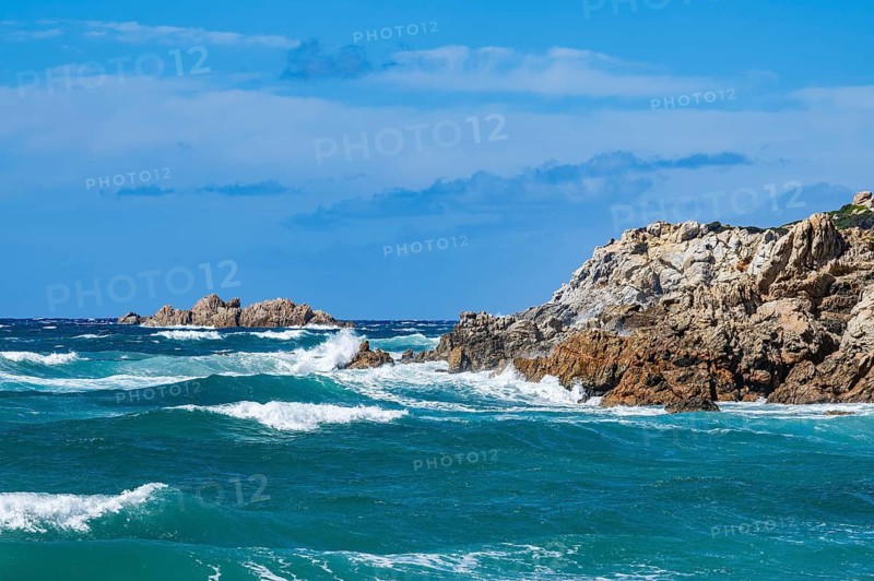 Coastline with emerald green and blue water on a sunny day at Rena Majori beach, Sardinia, Italy