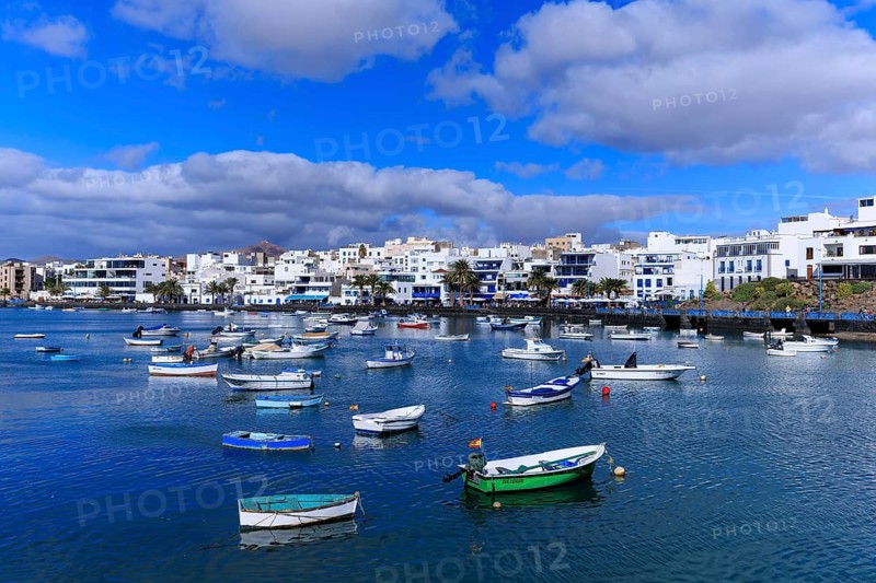 Lanzarote, Canary Islands, Spain, Europe, Charco San Gines harbour in Arrecife, harbour full of boats in front of a coastal town with white buildings and blue sky