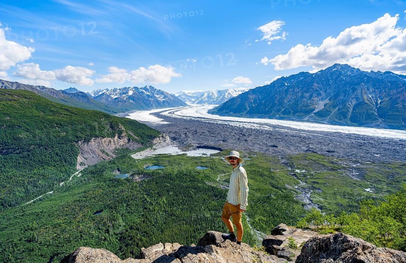 Young man enjoying the view, view of impressive mountain landscape with Matanuska glacier and glaciated mountain peaks, Lion's Head, Chugach Mountains, Alaska, USA