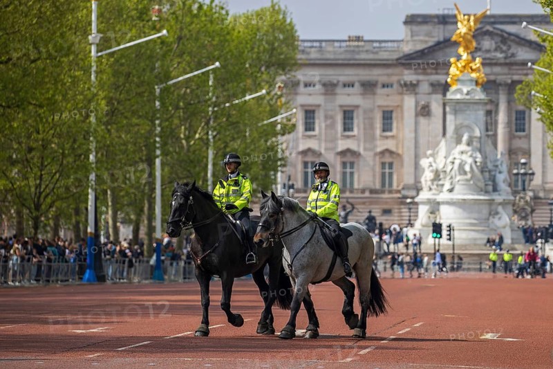Mounted police officers riding along The Mall from Buckingham Palace, London, United Kingdom