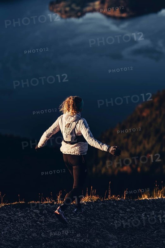 Trail running in autumn on the Jochberg on Lake Walchensee against the wonderful backdrop of the Alps, Bavaria, Germany