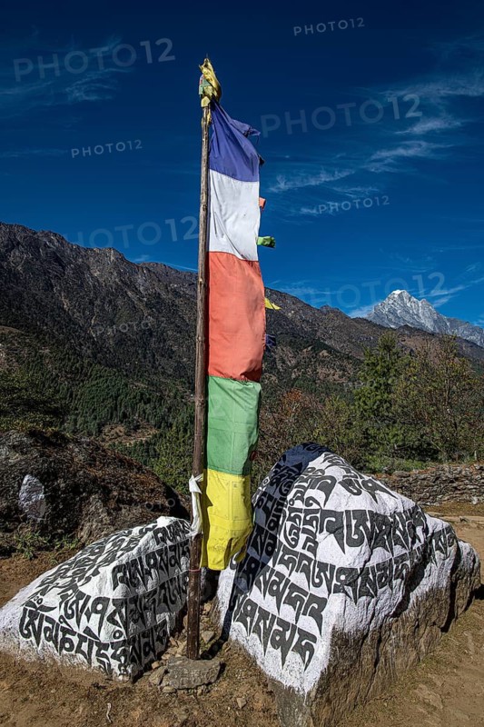 Buddhist prayer flag and holy mantras on manistones on the way to Mount Everest, Solu Khumbu, Himalayas, Nepal