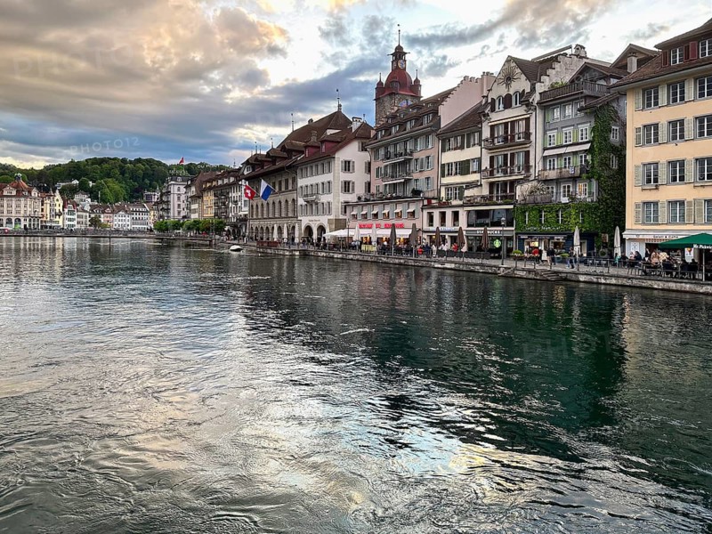 Historic buildings reflected in the river under a dramatic sky, Lucerne, Switzerland