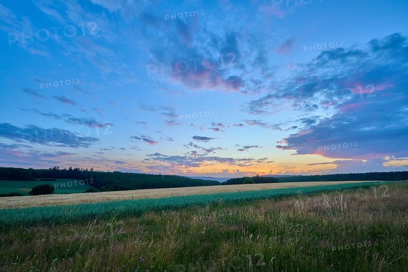 A quiet sunset with soft shades of pink in the sky that stretches across a wide field, summer, Großheubach, Miltenberg, Spessart, Bavaria, Germany