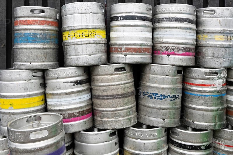 Pile of empty steel beer and cider kegs, UK
