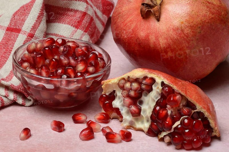 Opened pomegranate and pomegranate seeds in skin, Punica granatum