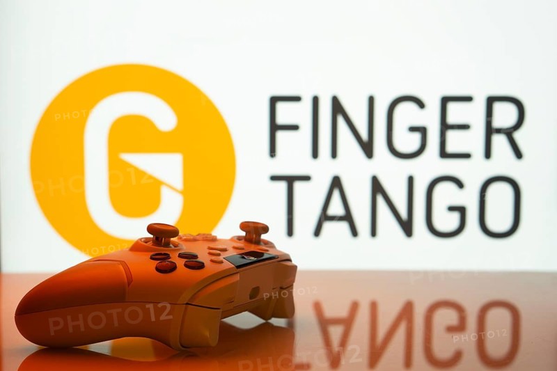 Dhaka, Bangladesh- 20 Mar 2025: A close-up of a white gamepad with the Finger Tango seen on screen in the background