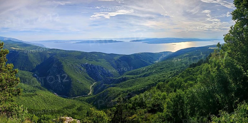 Panoramic view over green mountains of Kvarner Gulf Bay with sea in the background, Croatia