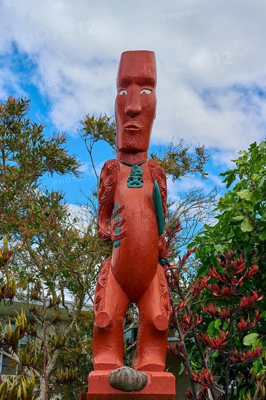 Red Maori wooden statue with detailed carvings and a distinctive face, New Zealand Maori Arts and Crafts Institute, Te Puia, Whakarewarewa, Rotorua, North Island, New Zealand