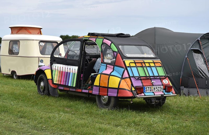 A brightly painted Citroën 2CV stands in front of caravans and tents, colorful view, Citroën 2CV at a duck meeting in Kropp, Schleswig-Holstein, Germany