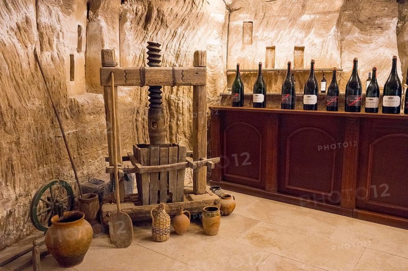 Ancient wine presses with surrounding bottles in a rustic cellar, sales room, Milestii Mici Winery, Mile?tii Mici, Republic of Moldova, Moldova