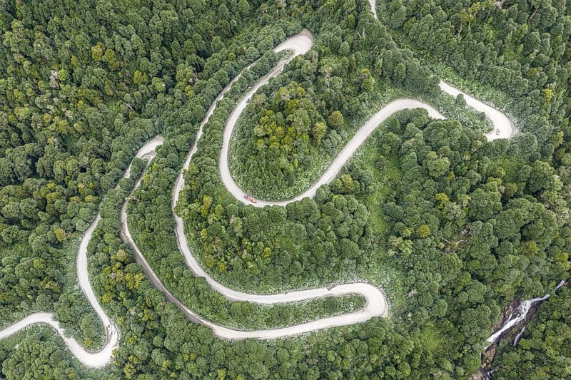 Aerial view of a winding road (Carretera Austral) through dense forest, south of Puyuhuapi, Aysén Region, Chile