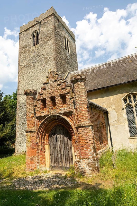 Red brick Tudor porch and flint tower of village parish church of Saint Andrew, Winston, Suffolk, England, UK